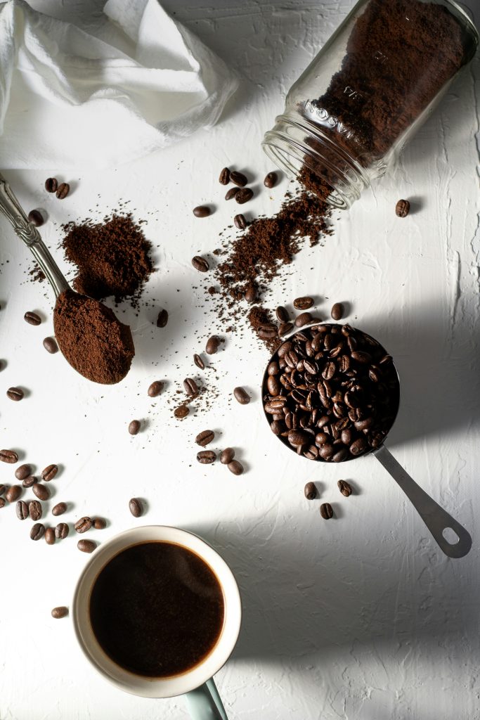 Il s'agit d'une image avec des grains de café non moulu, puis une mouture de café et un café dans une autre tasse.